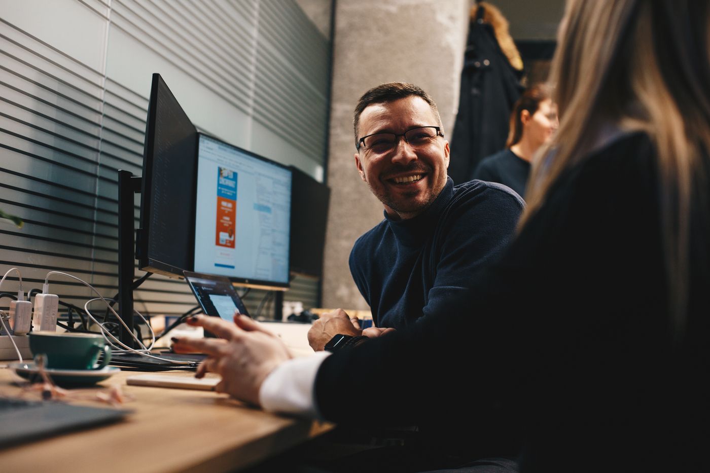 Jovica Bojić working with a colleague at a desk, code on the monitor — leading frontend product development